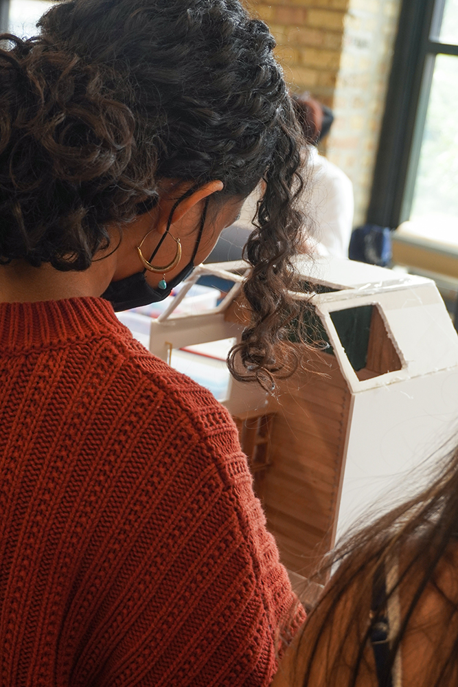 A young artist builds an abstract geometric sculpture.