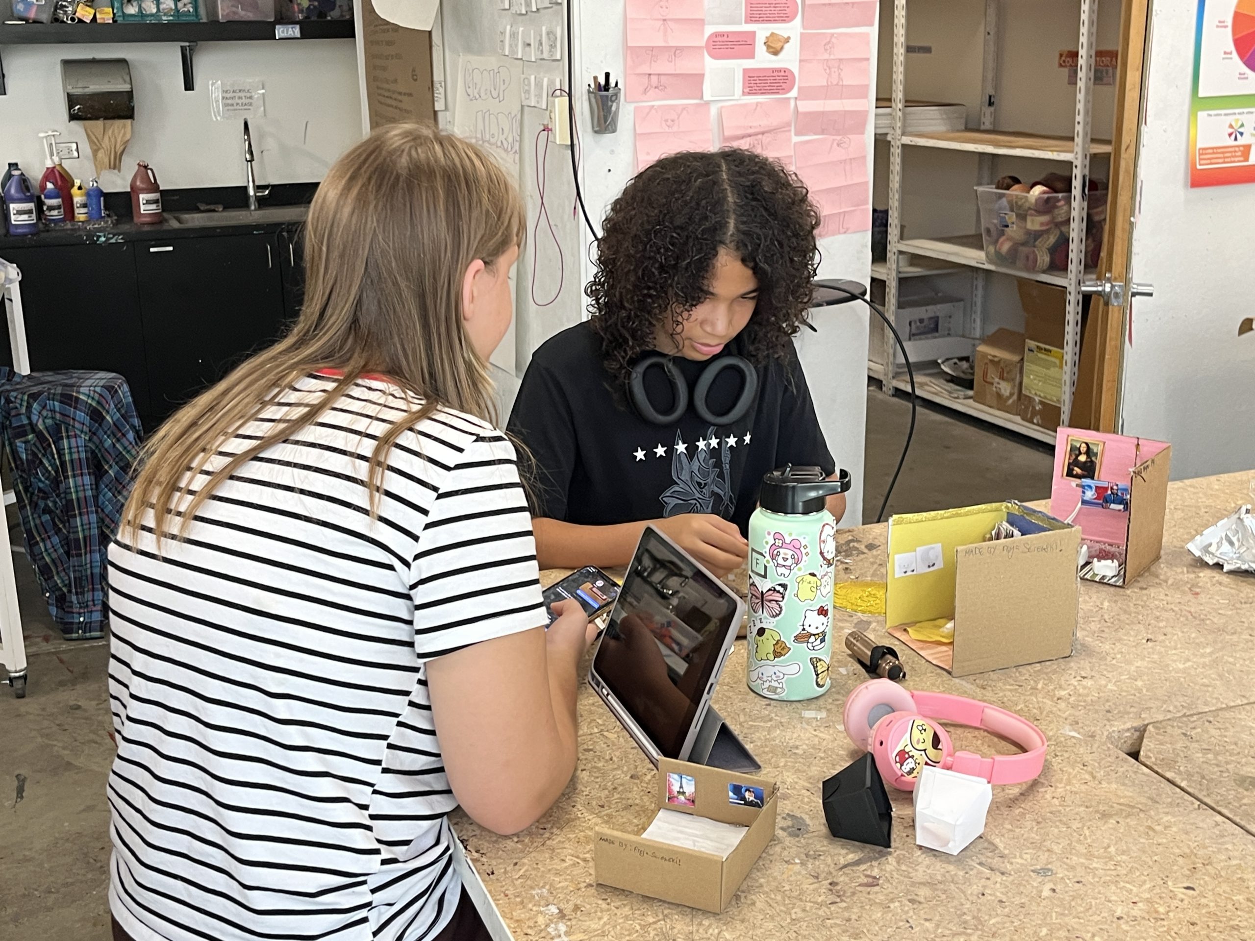 Young artists sculpting mini world dioramas.