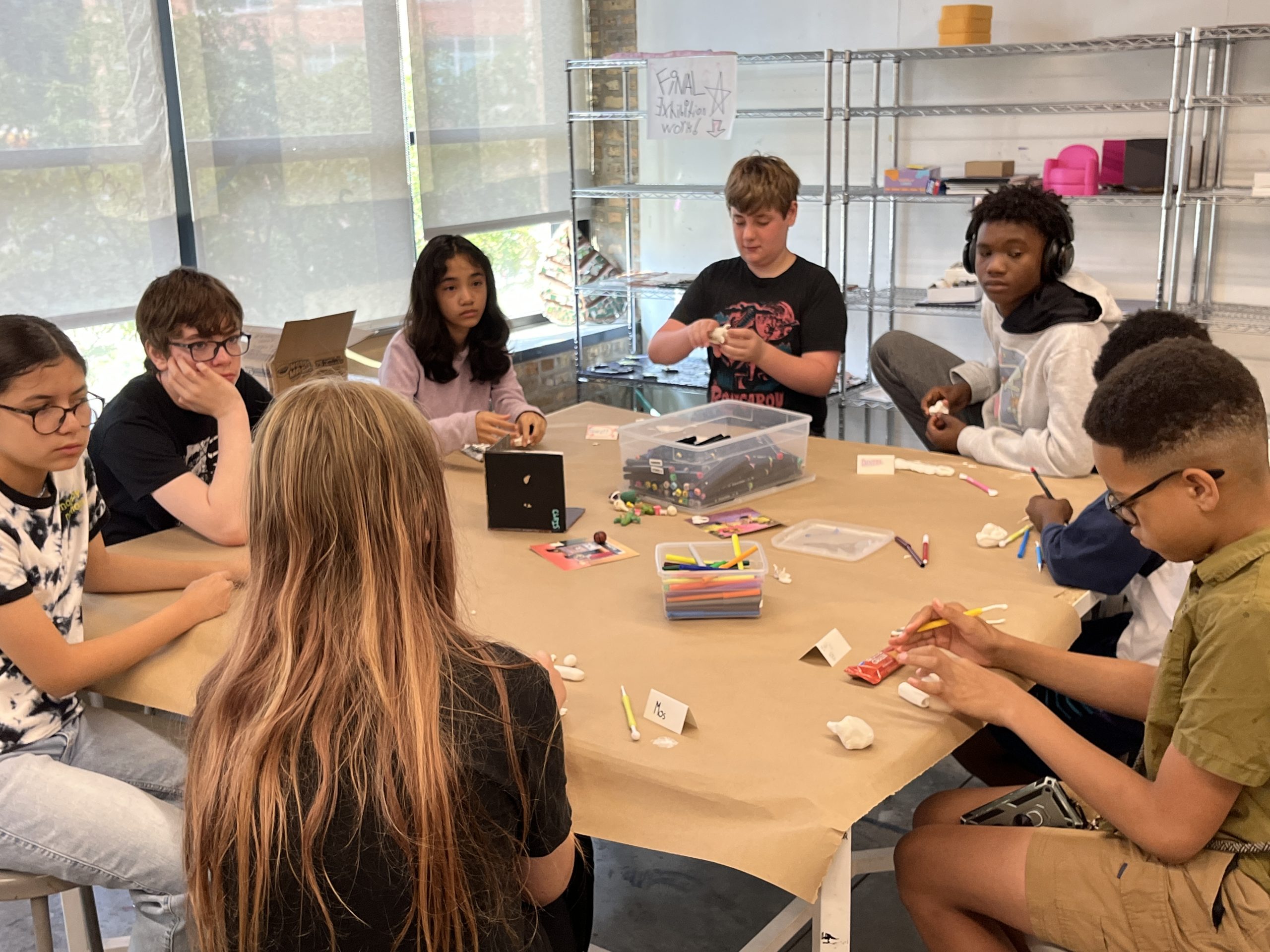 Young artists sculpting mini world dioramas.