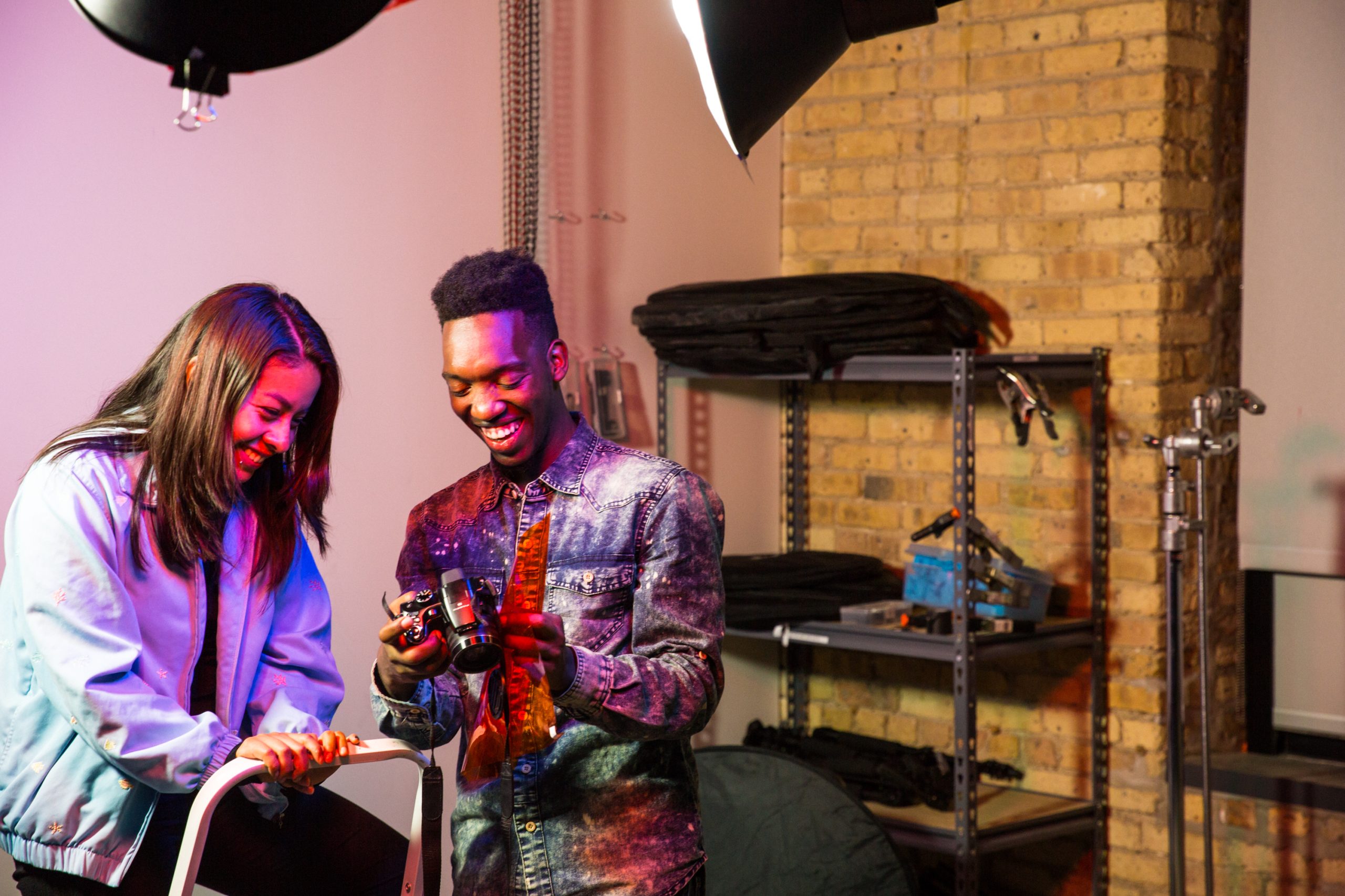 ForTheMedia_170907_MarwenAnnualReport2016_LightingLab-110 - Marwen A smiling young artist shows a preview of a photo on their camera to another person.