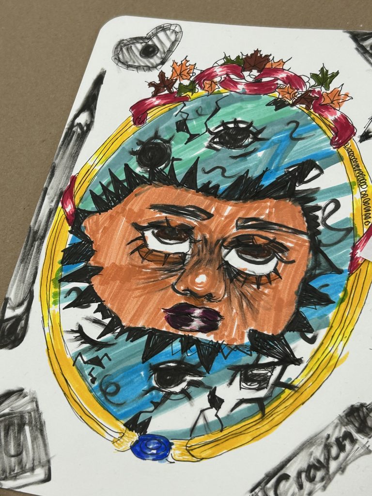 Child’s colorful portrait: a person with brown skin inside a yellow oval frame, wearing a flower crown against a rainbow background. A doodled heart sits above.