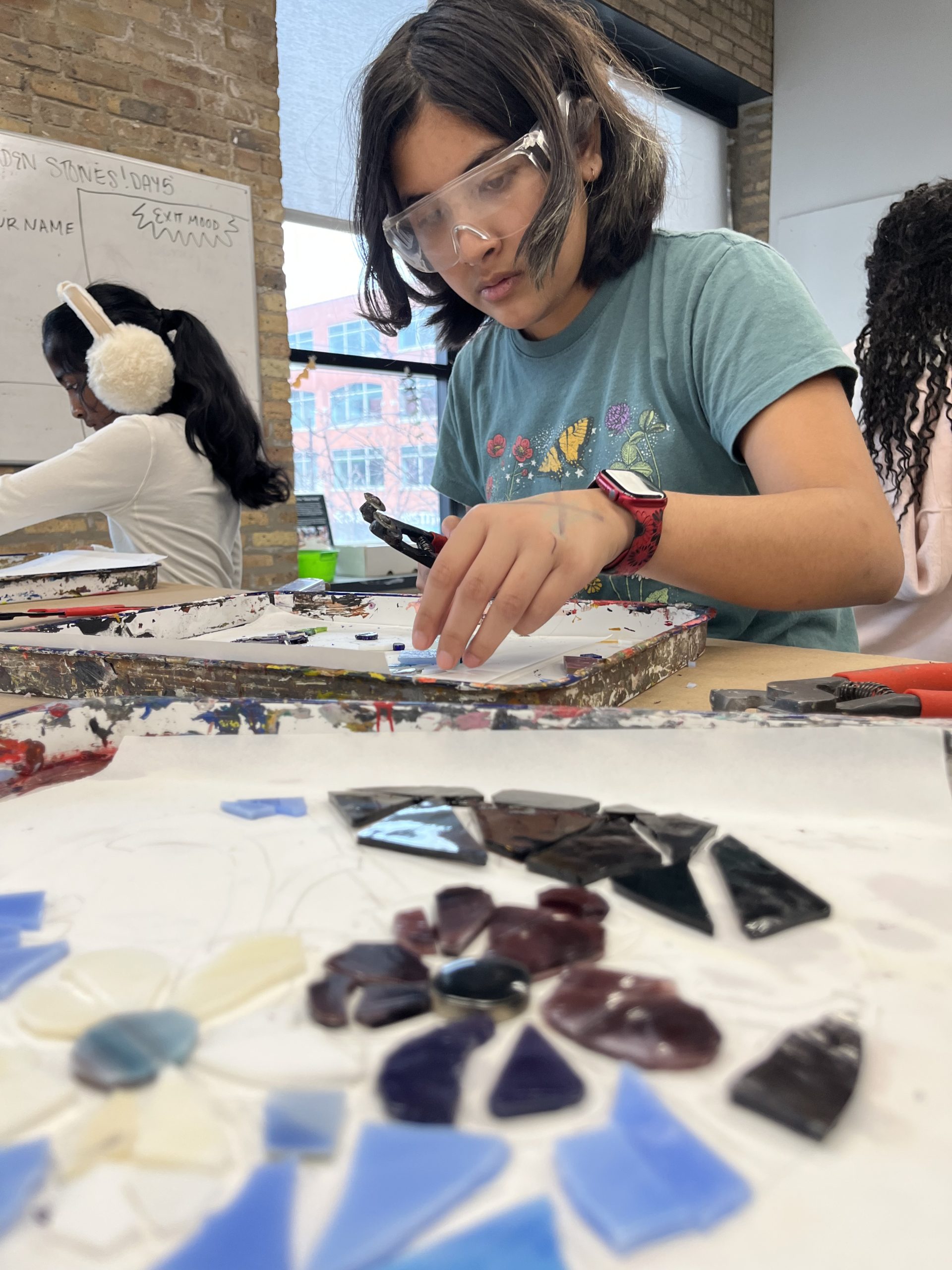 A Marwen young artist creates a mosaic piece
