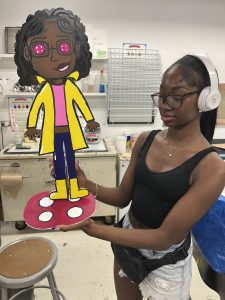 A Marwen young artist shows off their 3D paper sculpture